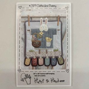 Pattern cover for Heart to Hand's Clothesline Bunny #389 wool applique wall hanging featuring whimsical bunny on clothesline with spring flowers, mason jars, primitive SPRING banner, and gray polka dot background, sized 14x18 inches
