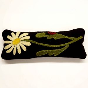 Rectangular wool pin cushion in black featuring cream daisy with yellow center, green stems, and small red ladybug applique